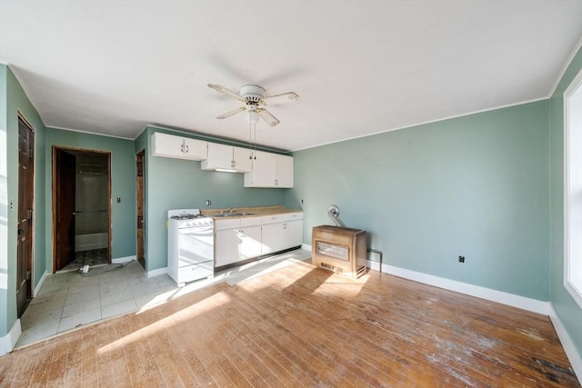 kitchen featuring ceiling fan, sink, light hardwood / wood-style floors, white cabinetry, and white gas stove