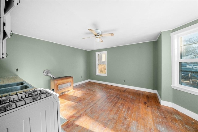 kitchen with hardwood / wood-style floors, gas stove, and ceiling fan