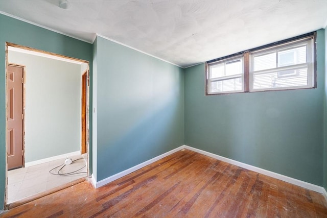 spare room featuring hardwood / wood-style floors and ornamental molding