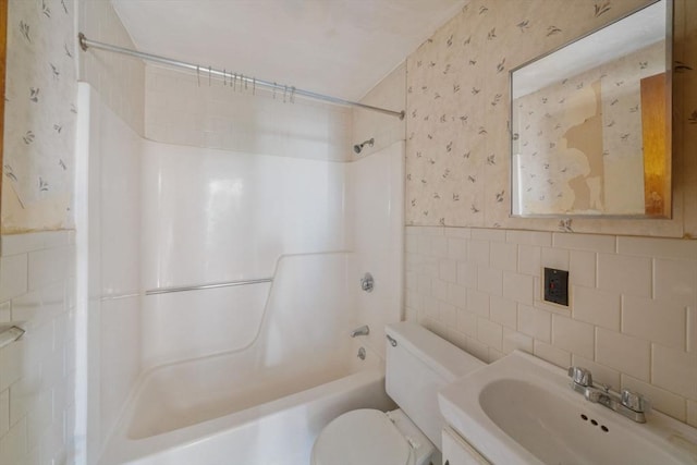 full bathroom featuring  shower combination, vanity, tile walls, and toilet