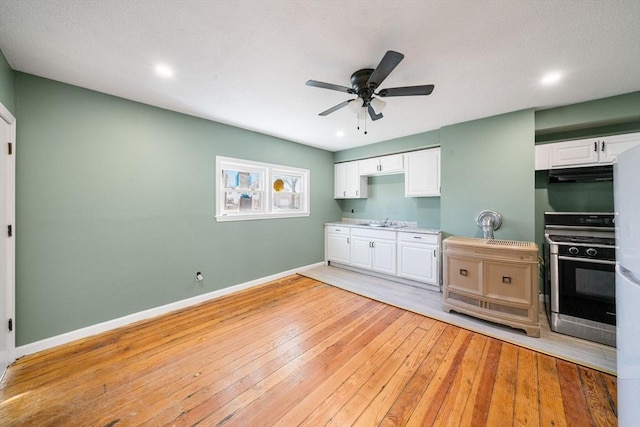 kitchen with white cabinets, appliances with stainless steel finishes, light hardwood / wood-style flooring, and sink