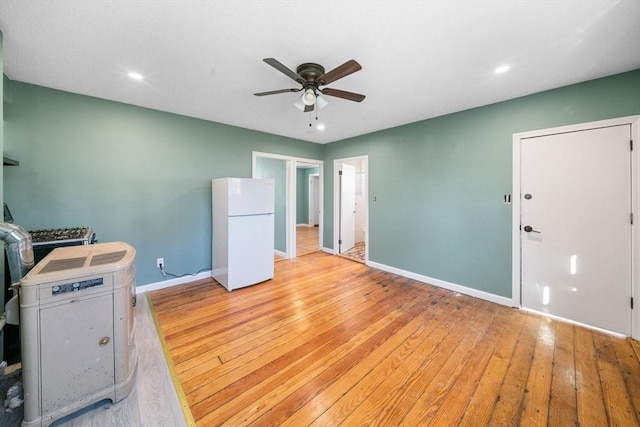 unfurnished bedroom featuring ceiling fan, white fridge, and light hardwood / wood-style floors