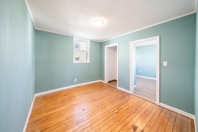 interior space with crown molding, a textured ceiling, and hardwood / wood-style flooring