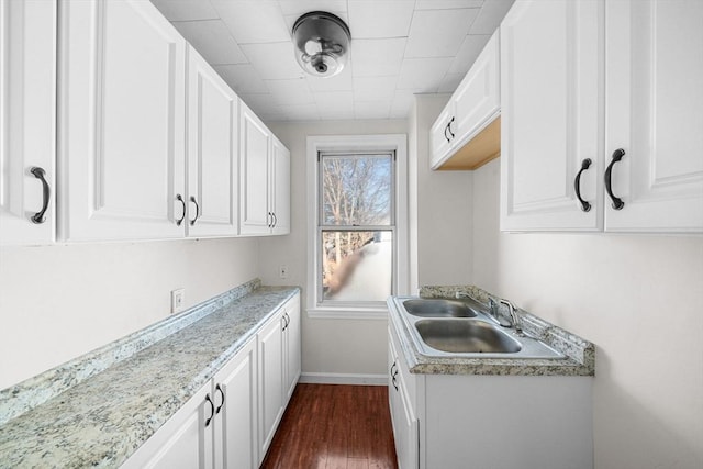 kitchen featuring sink, white cabinets, and dark wood-type flooring