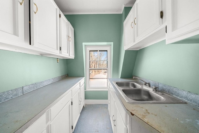 kitchen featuring white cabinetry, sink, and ornamental molding