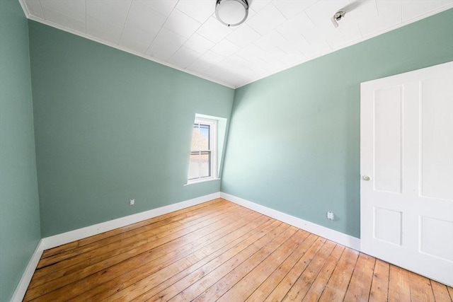 empty room featuring hardwood / wood-style floors and ornamental molding