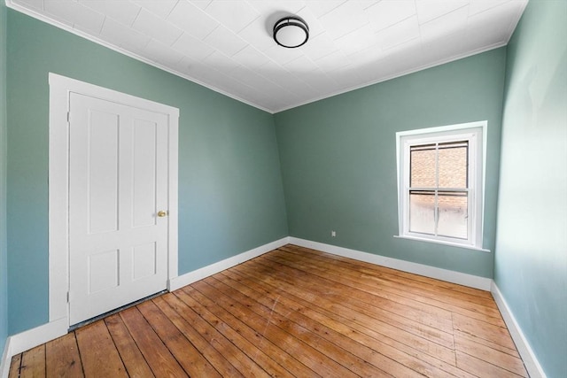 empty room featuring ornamental molding and light wood-type flooring