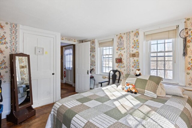 bedroom featuring wallpapered walls and wood finished floors