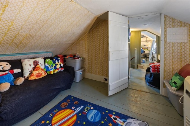 bonus room featuring lofted ceiling, hardwood / wood-style floors, and wallpapered walls