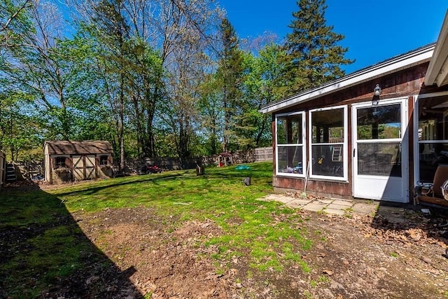 view of yard with a fenced backyard, an outbuilding, and a shed