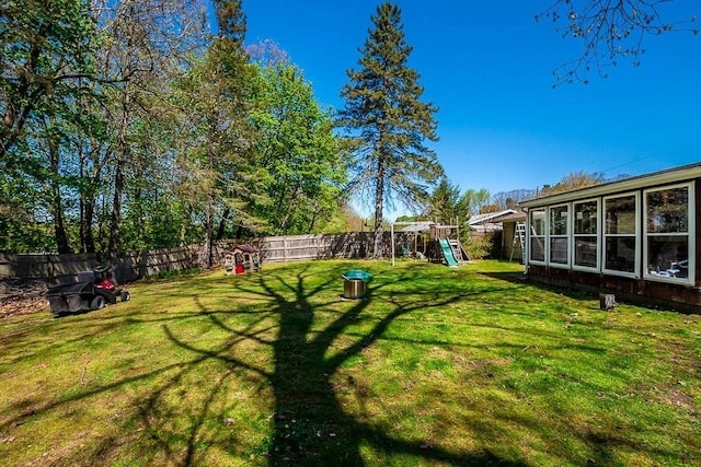 view of yard featuring a fenced backyard and a playground