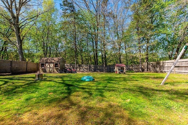 view of yard with an outdoor structure, a shed, and a fenced backyard