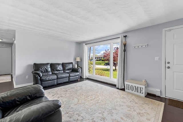 living area with baseboards, a baseboard radiator, and dark wood-type flooring