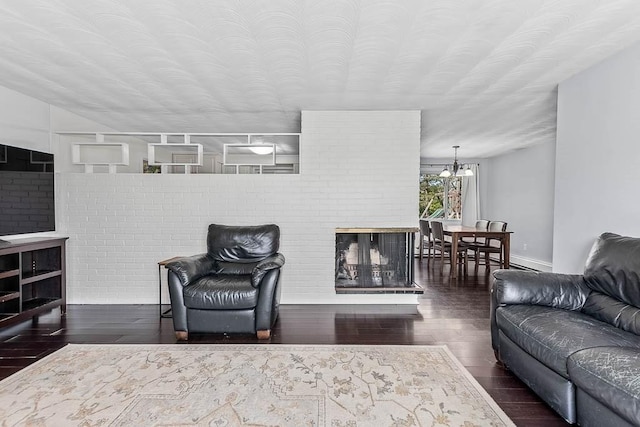 living room with baseboards, wood finished floors, and a notable chandelier