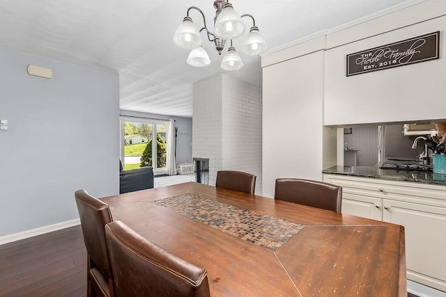 dining space featuring baseboards, a notable chandelier, and wood finished floors