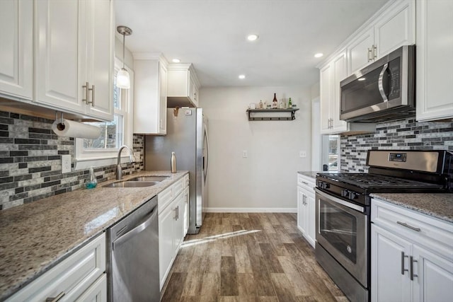 kitchen featuring appliances with stainless steel finishes, white cabinets, and a sink