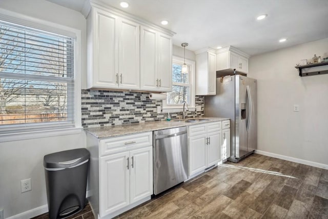 kitchen featuring stainless steel appliances, tasteful backsplash, a sink, and white cabinets