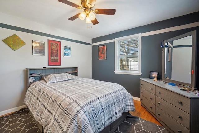 bedroom featuring dark wood-style floors, baseboards, and a ceiling fan