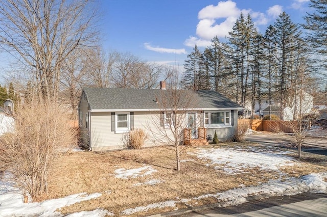 single story home with a shingled roof and a chimney