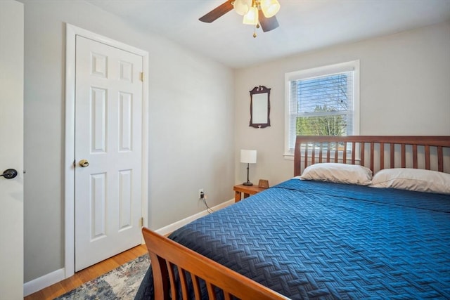 bedroom featuring a ceiling fan, baseboards, and wood finished floors