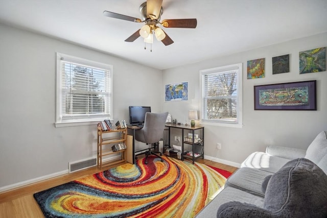 office space featuring a healthy amount of sunlight, visible vents, and wood finished floors