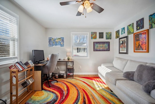 office featuring a ceiling fan, baseboards, and wood finished floors