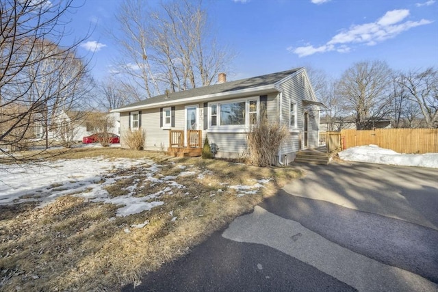 view of front of home with a chimney and fence