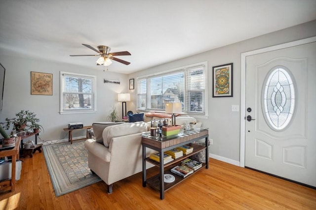 entryway with a ceiling fan, light wood-type flooring, and baseboards