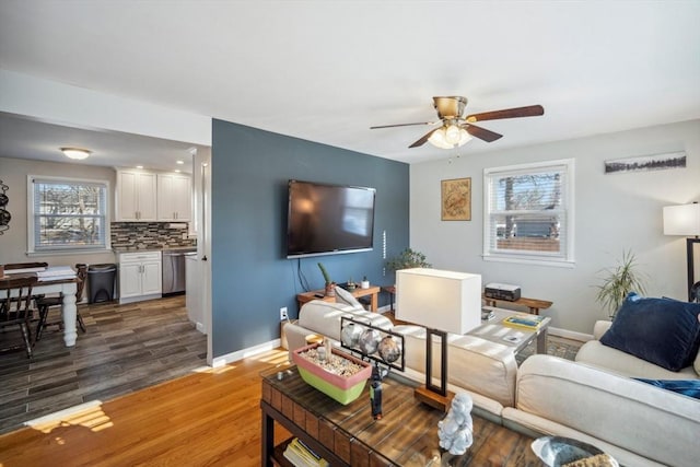 living area with ceiling fan, wood finished floors, and baseboards