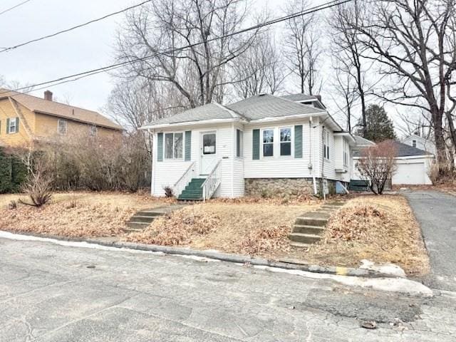 bungalow-style home with a garage and entry steps