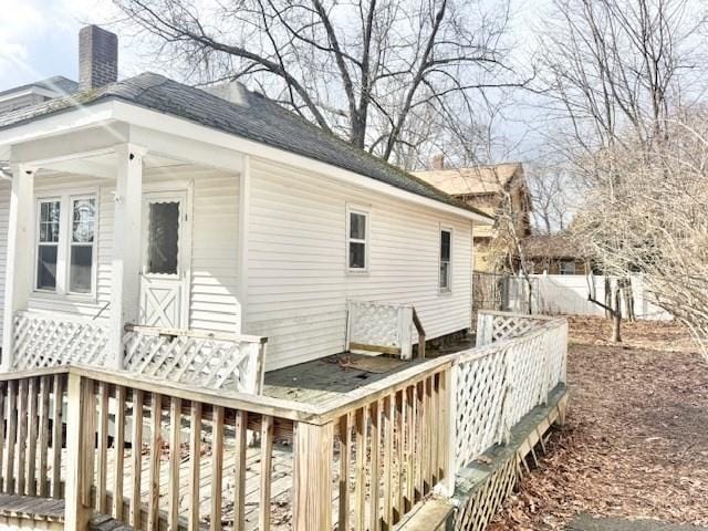 exterior space featuring fence, a chimney, and a wooden deck