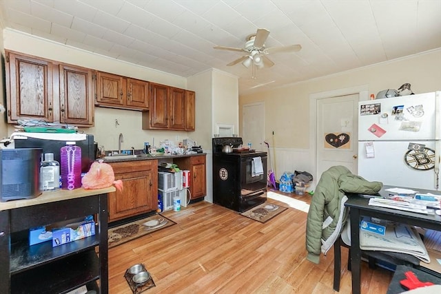 479 Main St, Hanson, MA 02341 - kitchen featuring black range with electric cooktop, a sink, brown cabinetry, ceiling fan, and freestanding refrigerator