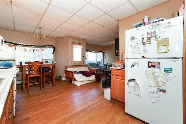 479 Main St, Hanson, MA 02341 - kitchen with freestanding refrigerator, a paneled ceiling, light wood-type flooring, light countertops, and open floor plan