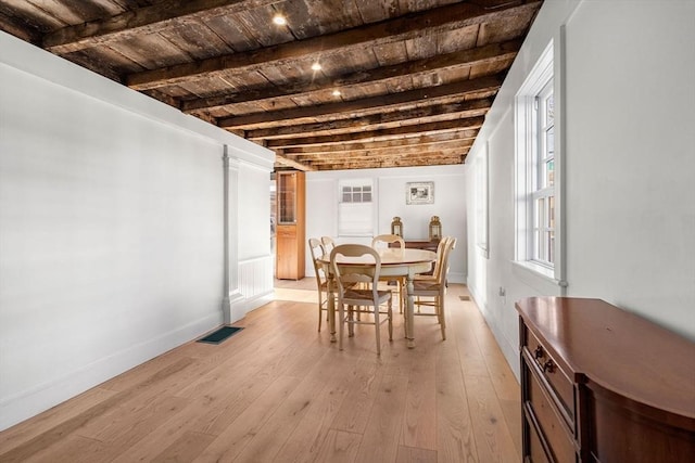 dining area with beamed ceiling, light wood-type flooring, and wood ceiling