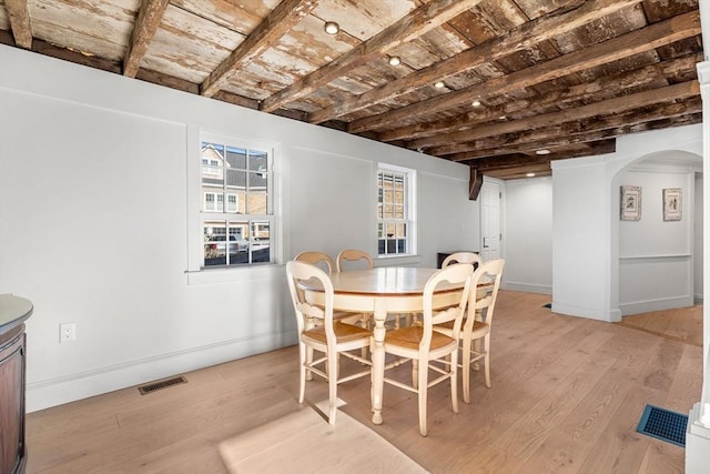 dining room featuring beamed ceiling, wooden ceiling, a healthy amount of sunlight, and light wood-type flooring