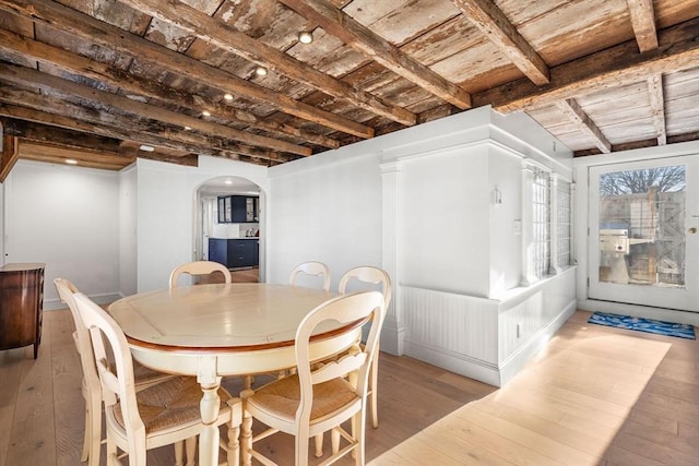 dining room featuring beam ceiling, wood ceiling, and light wood-type flooring