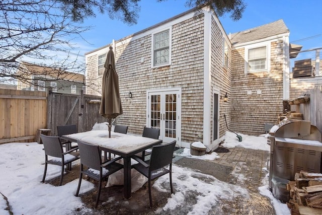 snow covered property featuring a patio and french doors