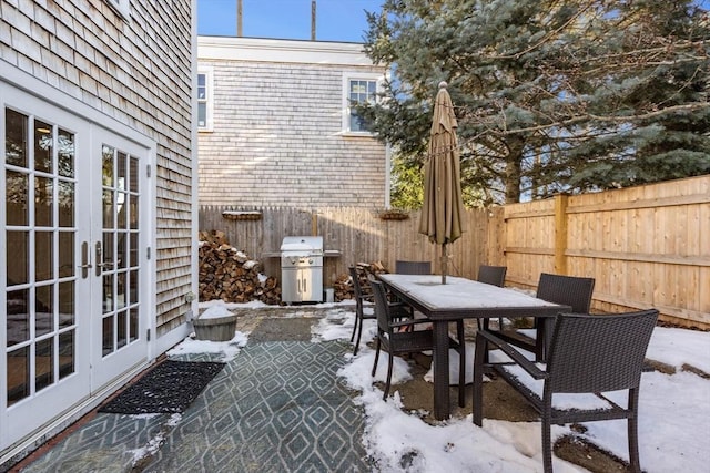 snow covered patio featuring area for grilling and french doors