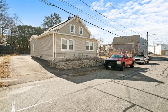 view of front facade featuring fence and driveway