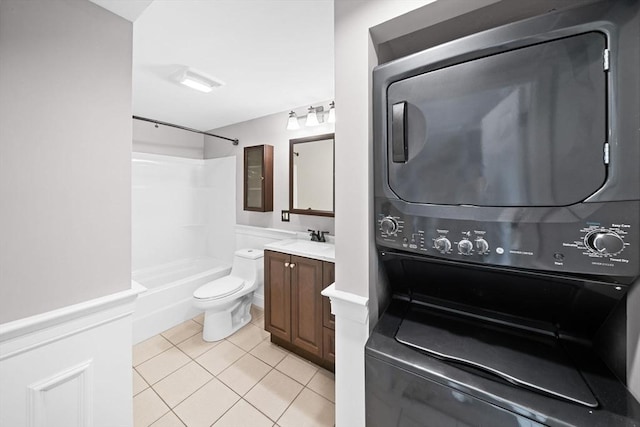 full bath with vanity, stacked washing maching and dryer, shower / tub combination, tile patterned floors, and toilet