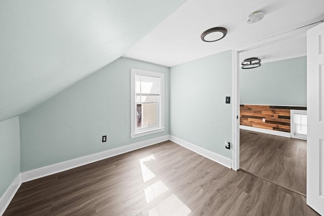 bonus room featuring vaulted ceiling, baseboards, and wood finished floors