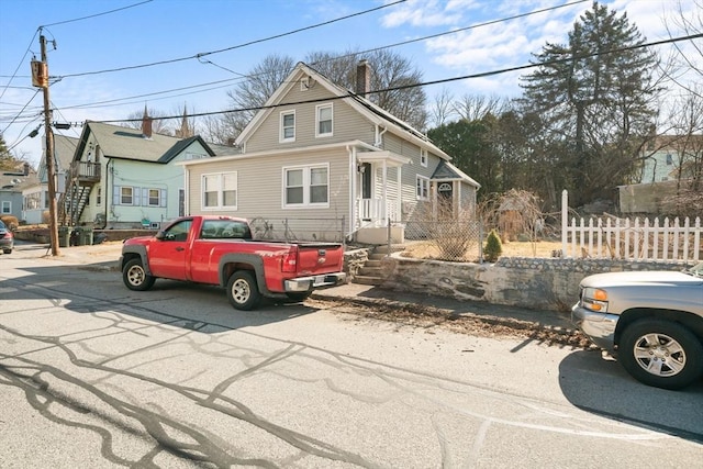 view of front of home featuring a chimney and fence