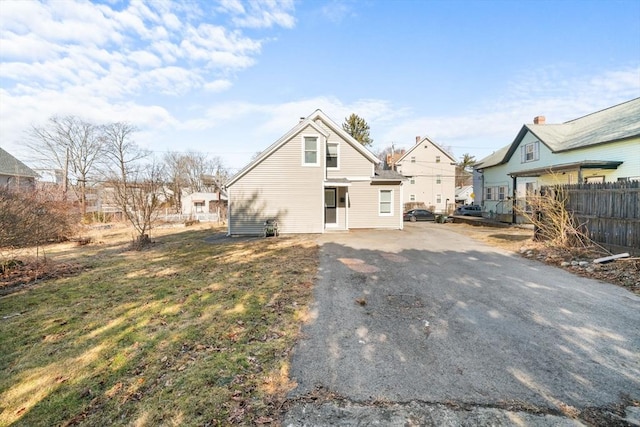 exterior space with aphalt driveway, a residential view, and fence