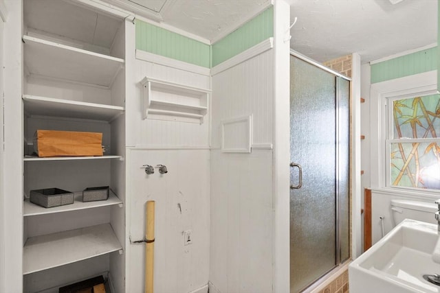full bathroom featuring crown molding and a stall shower