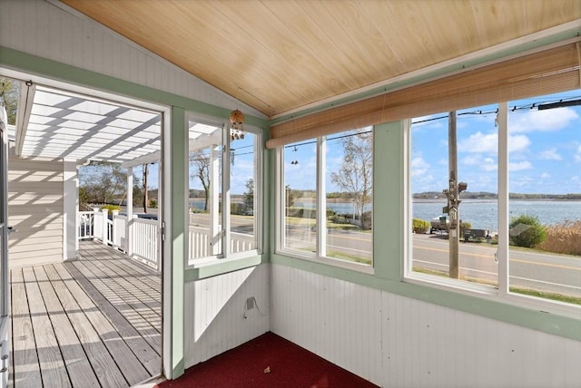 unfurnished sunroom featuring wood ceiling, a water view, lofted ceiling, and wooden walls