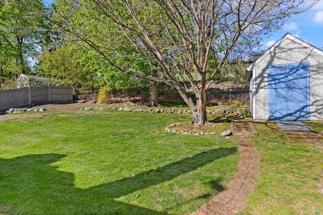 view of yard with fence, an outdoor structure, and a shed