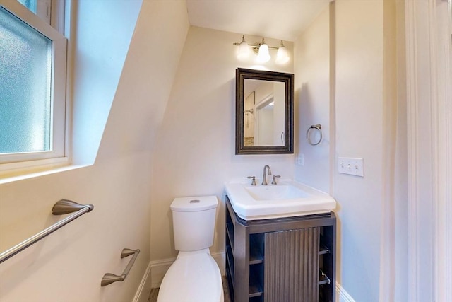 bathroom with vanity, baseboards, and toilet