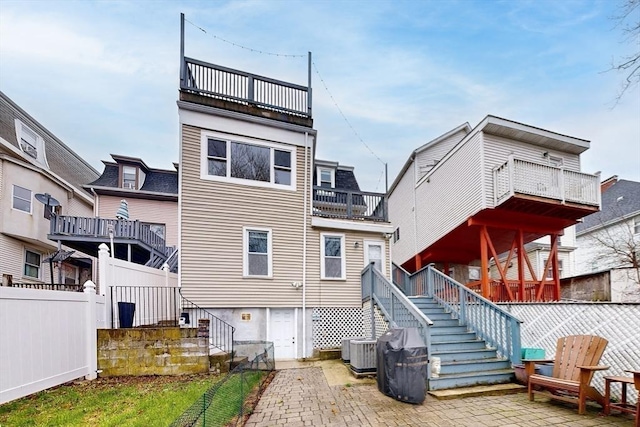back of house with fence, stairway, cooling unit, a patio area, and a balcony