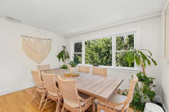 dining space with baseboards, visible vents, and light wood-style flooring