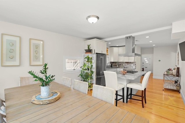 dining space with recessed lighting, baseboards, and light wood finished floors